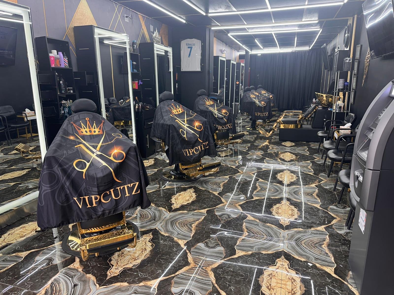 Inside V.I.P Cutz — black and gold luxury barbershop interior with gold barber chairs in Clifton, NJ